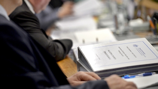 Commissioners sitting at a bench reviewing folders